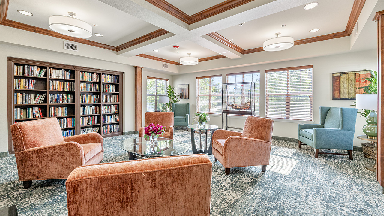 The library at Heatherwood with shelves of books and comfortable seating
