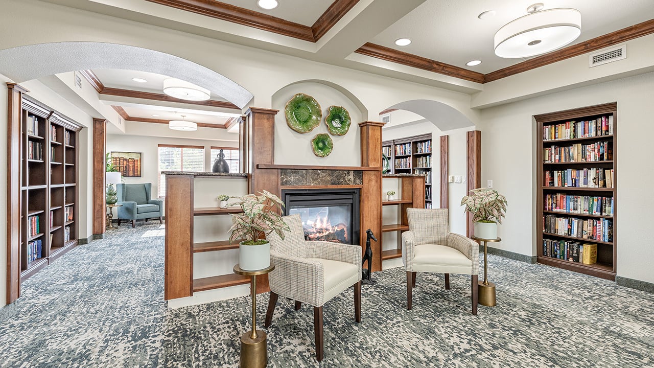 The library at Heatherwood with shelves of books and comfortable seating