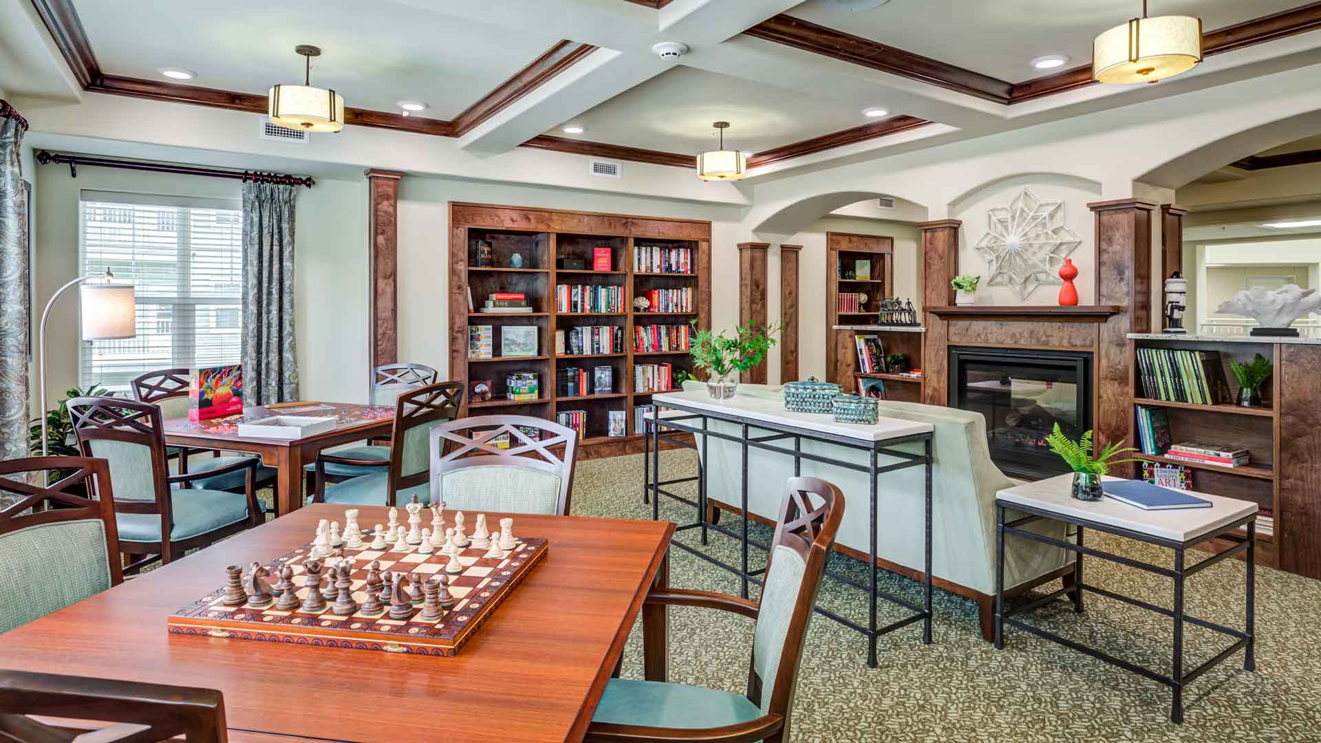 The library at Heatherwood with shelves of books and comfortable seating